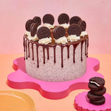 Oreo Cookies & Cream Cake with chocolate ganache drip, Oreo buttercream, and whole Oreos on top by Crumbs & Doilies.